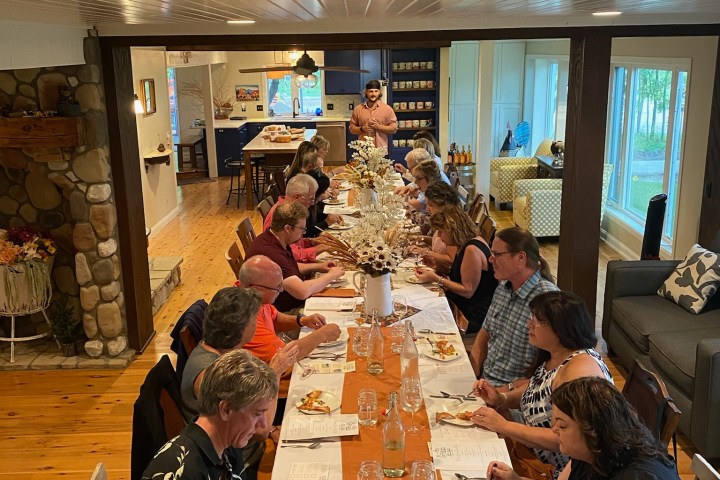 a group of people sitting at a table with a cake